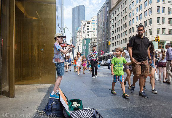 Young boy working hard playing the violin on 5th Ave., New York City